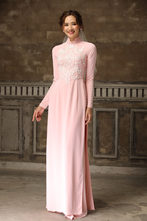 Pink ao dai with white lace patterns